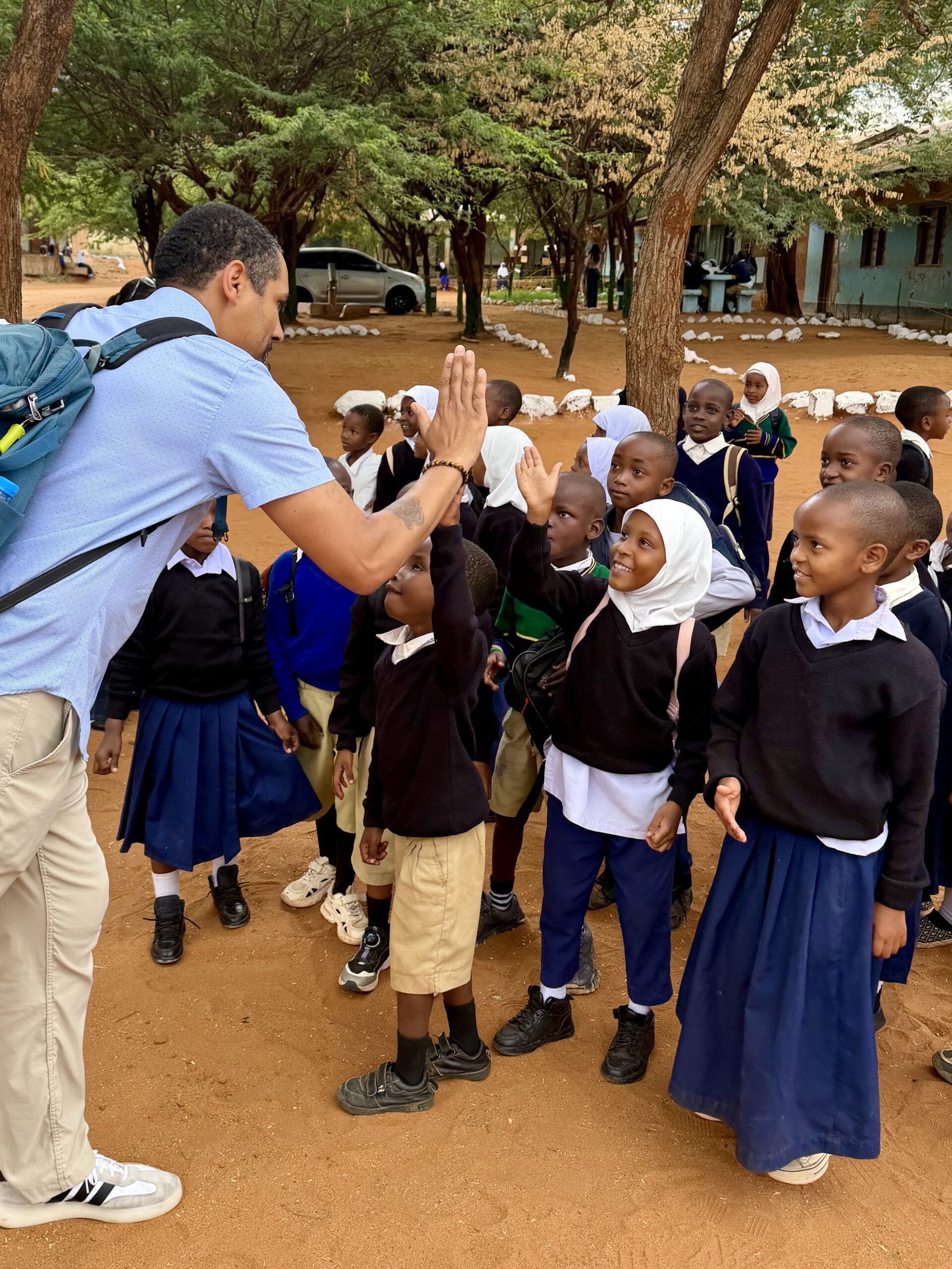Volunteer high-fiving schoolchildren in Tanzania